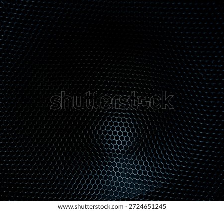 Dark close-up of a speaker grille with repeating perforated pattern, ideal for audio, music, sound, or technology-related backgrounds.