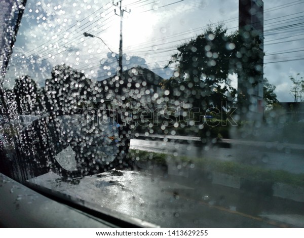 Dark cloud, an heavy raining.  The road are wet. To\
be safe,  slowly and carefully on driving,Raindrops on the\
windshield on heavy rain
