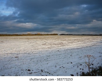 Dark Clouds Above A Field Covered In A Light Dusting Of Snow, Above The Town Of Dartmouth, South Devon, UK