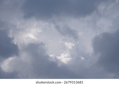 Dark clouds gather overhead with hints of bright sky visible as the weather changes in an afternoon sky