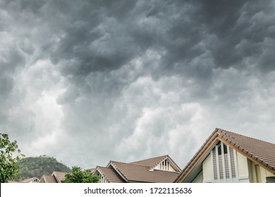 Dark clouds going to heavy rain over the house roof.