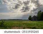 Dark clouds hovering over an old barn in the countryside, the calm before the storm,