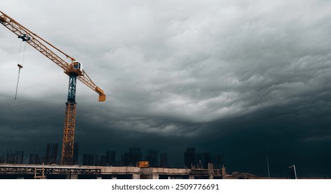 Dark clouds on sky at construction site with tower crane