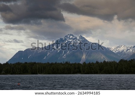 Dark clouds over mountain behind Lake Lucille on a spring day in Wasilla, Alaska.