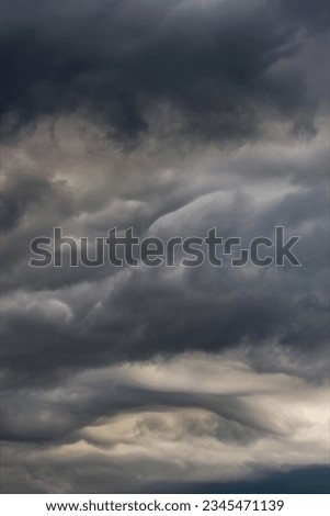 Dark clouds in the sky during a storm. The clouds are ominous and foreboding, and they are a sign of bad weather to come.