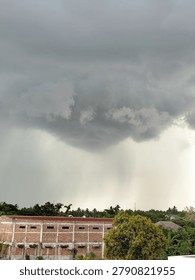 Dark clouds are visible like small tornado clouds carrying rain water.