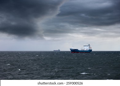 Dark Cloudy Stormy Sky With Ship And Waves In The Sea.