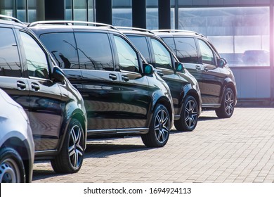 Dark Colored Passenger Vans In A Parking Lot