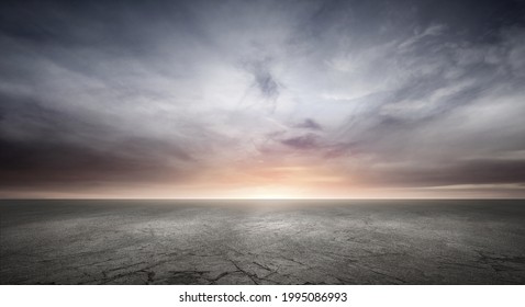 Dark Concrete Floor Background with Dramatic Sky Clouds and Sunset Horizon