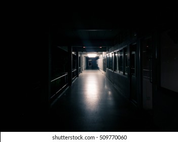 Dark Corridor Of The Abandon Building With Many Door - Light Shining From The End Of Hallway