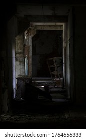 A Dark Corridor In An Abandoned Building. Vertical Photo Of A Cluttered Corridor In Ruins. Abandoned Building. Horror. Dark Room.