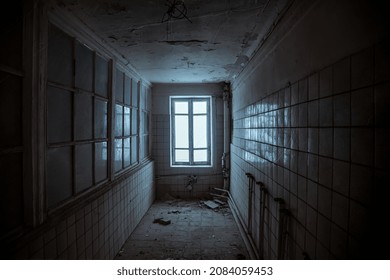 Dark corridor and window  An old room in an abandoned building  Light from the window  Scary atmosphere  An old abandoned building  The interior an abandoned house  Tiles shabby walls 