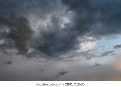 Dark, dense clouds fill the sky, characteristic of thunderstorm or squally weather. These thick storm clouds often bring short, intense downpours, heavy rain showers, and sometimes fog. The image captures the heavy, low-hanging cloud mass,