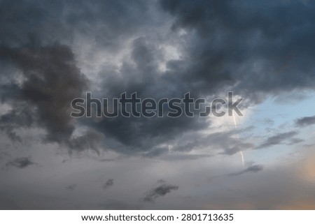 Dark, dense clouds fill the sky, characteristic of thunderstorm or squally weather. These thick storm clouds often bring short, intense downpours, heavy rain showers, and sometimes fog. The image captures the heavy, low-hanging cloud mass,