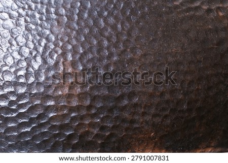 Dark dimpled copper texture with hammered metal surface pattern