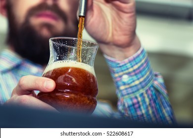 Dark draft beer poured by bartender - Powered by Shutterstock