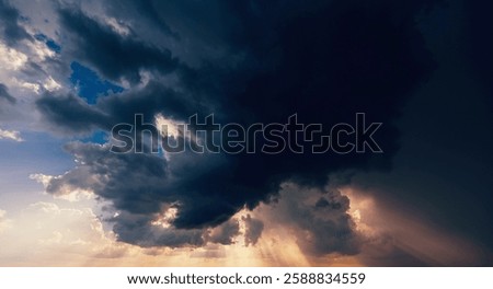 dark dramatic clouds in a cloudy sky in a storm and rain at sunset