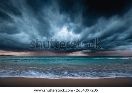 Dark dramatic seascape with stormy clouds, distant rain and waves crashing on sandy beach, San Vito Lo Capo, Sicily, Italy