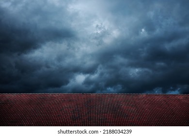 Dark Dramatic Sky Before Rain And Storm. Cyclone Is Coming With Black Windy Cloud. House Cover By Red Tiles Roof As Foreground. Weather And Season Change