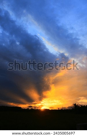 Dark dramatic sky horizon and orange sunset clouds.
