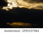 dark dramatic sky at sunset with sun rays through the clouds