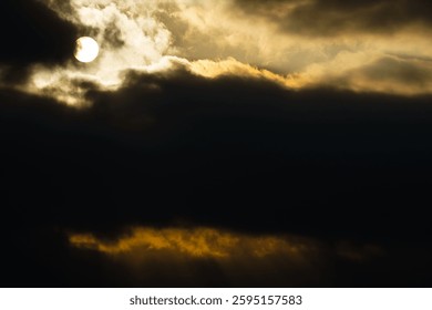 dark dramatic sky at sunset with sun rays through the clouds
