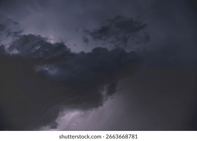 Dark, dramatic storm clouds gather on the horizon, hinting at an approaching thunderstorm. The sky is a canvas of intense grays and deep blues, with a powerful sense of impending weather. This image c