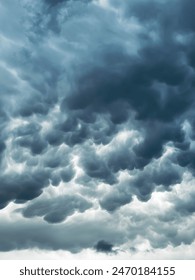 Dark, dramatic storm clouds with a textured, billowy appearance fill the sky, creating a sense of impending weather change. The shades of gray and white highlight the dynamic cloud formations