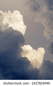 Dark and dramatic supercell, cumulus clouds forming into summer thunderstorm sunlit from side. Meteorology, weather and climate change concepts
