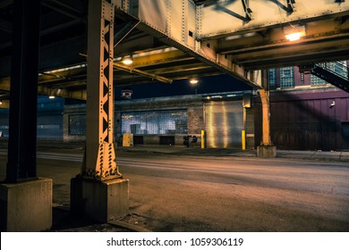 Dark And Eerie Chicago Urban City Street Night Scenery With Elevated CTA Train Tracks, Vintage Industrial Warehouses And Factories.