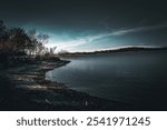 Dark eerie lake with rays of light