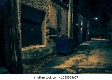 Dark Empty And Scary Urban City Street
Alley With A Vintage Warehouse Loading Dock And A Garbage Dumpster At Night

