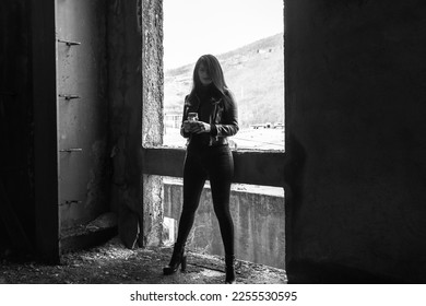 Dark girl in abandoned building, black jacket, black jeans and shoes. Darkness horror and halloween background concept. - Shutterstock ID 2255530595