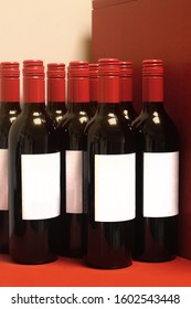 Dark Glass Bottles Of Wine With Red Lids And Blank White Generic Labels