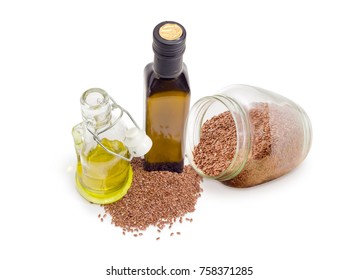 Dark gllass bottle and transparent gllass bottle with open lockable lid of the flaxseed edible oil, gllass jar and pile of linseeds beside on a white background