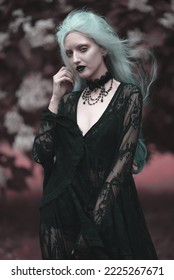 Dark goth girl standing in the forest, portrait of a wiccan witch performing magic - Shutterstock ID 2225267671