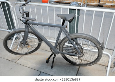 dark gray bicycle unchained standing on sidewalk in Manhattan New York in front of police barricade.  10-21-2021