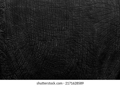 Dark gray black stone background with a concrete wall texture resembling dinosaur skin. - Shutterstock ID 2171628589