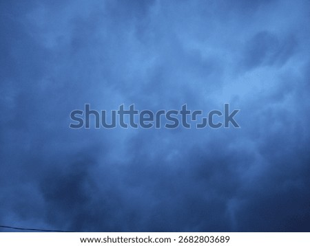 Dark gray clouds cover the sky, casting a gloomy and calm atmosphere as the sun hides behind the thick overcast.