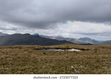 Dark gray storm clouds hovering over the fell peaks.