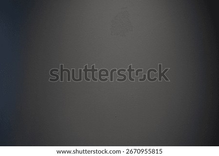 Dark gray textured wall surface, gradient lighting casting subtle shadows, complementing minimalist graphic design backgrounds
