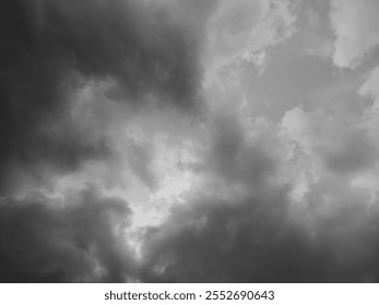 Dark gray thick clouds background in the sky.  Soft white and thick gray cumulus clouds. Perfect for backgrounds and designs. Black and white style.