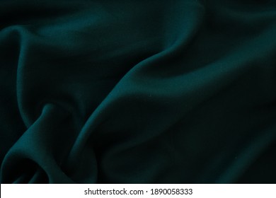  Dark green fabric with large folds and copy space.