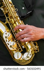 The Dark Green T Shirt Man's Hand With Golden Shiny Alto Saxophone With Strap.