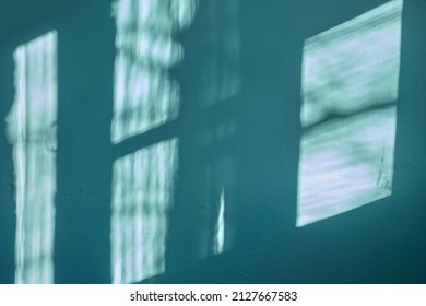 A Dark Green Wall With Beautiful Sun Light And Window Frame Shadow Shine On. Background. Morning Sunlight Shine Through  The Window  On Dark Green Wall Inside The Room.