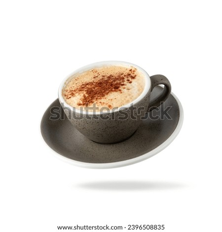 Dark grey granite texture cup cappuccino coffee with cinnamon topping flying isolated on white background. Pastry shop or cafe card element.