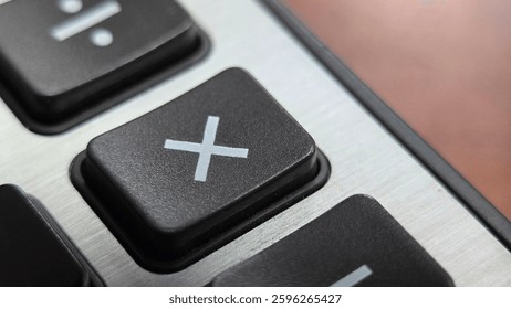 It is a dark grey multiplication key or button of a calculator marked with a white-colore 