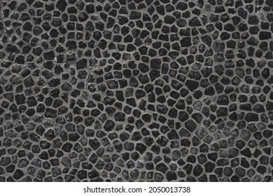 Dark grey outdoor building gravel material wall, Abstract black soil surface background, Rock texture, Pebble ground pattern.