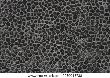 Dark grey outdoor building gravel material wall, Abstract black soil surface background, Rock texture, Pebble ground pattern.