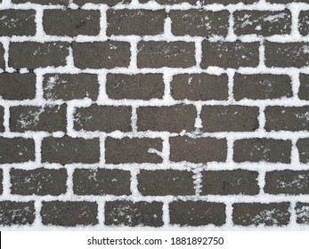 Dark Grey Pavement With White Snow In Gaps Between Rectangular Paving Stones. Winter Street Background.